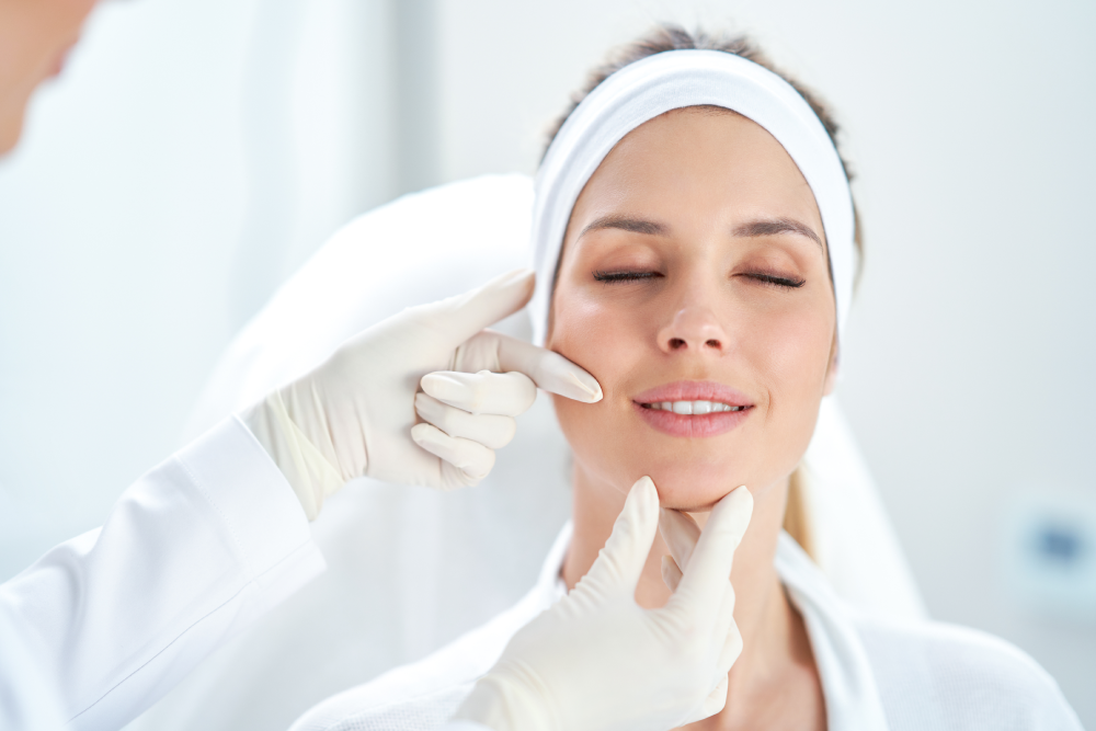 Med spa professional evaluating a woman's face during an injectables consultation.